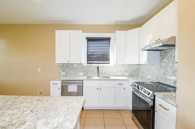 a kitchen with a sink stove and cabinets