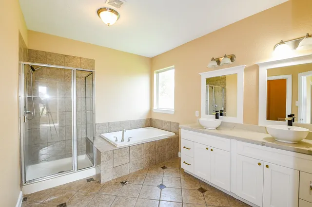 a spacious bathroom with a shower sink and mirror