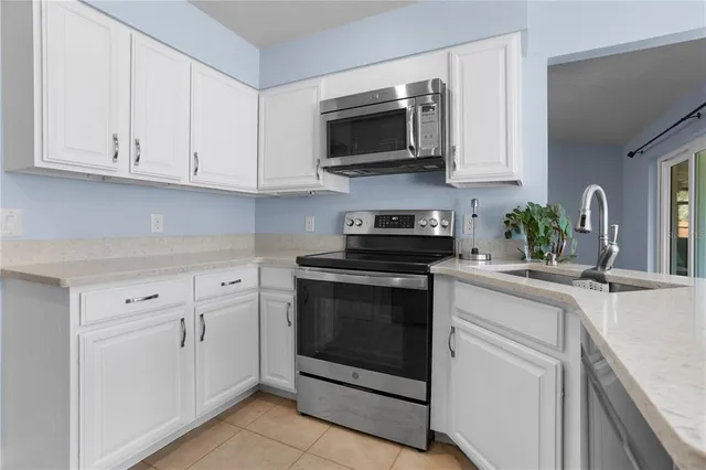 a kitchen with white cabinets and black appliances