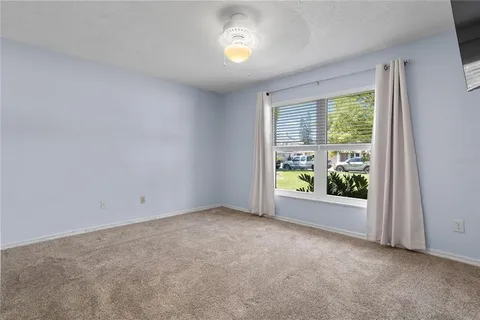 a view of an empty room and chandelier fan
