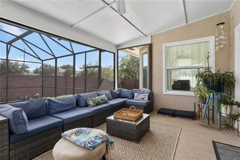 a living room with furniture and a floor to ceiling window