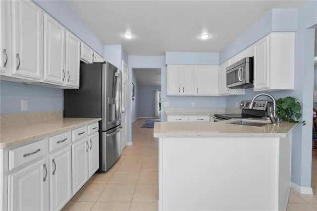 a kitchen with stainless steel appliances granite countertop white cabinets a refrigerator and a stove