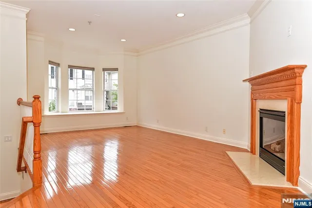 a view of a livingroom with wooden floor and a fireplace