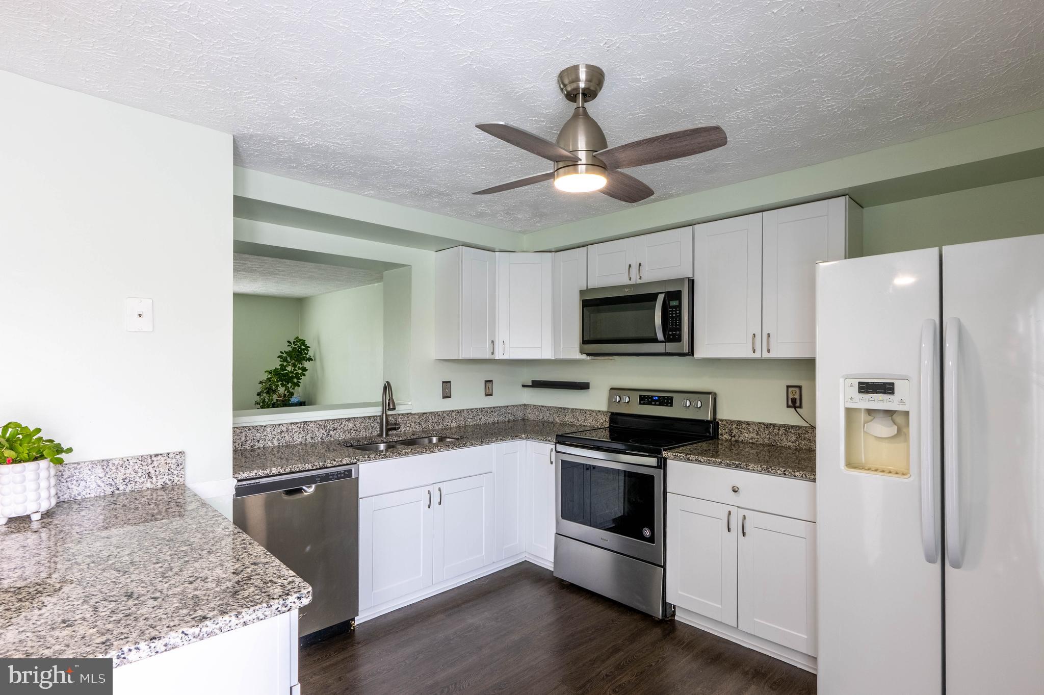 27 Cavan Green Nottingham, MD 21236 - Photo 12 of 31 a kitchen with stainless steel appliances granite countertop a sink a stove a refrigerator with white cabinets and wooden floor