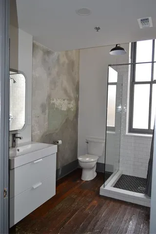 a bathroom with a toilet a sink and mirror