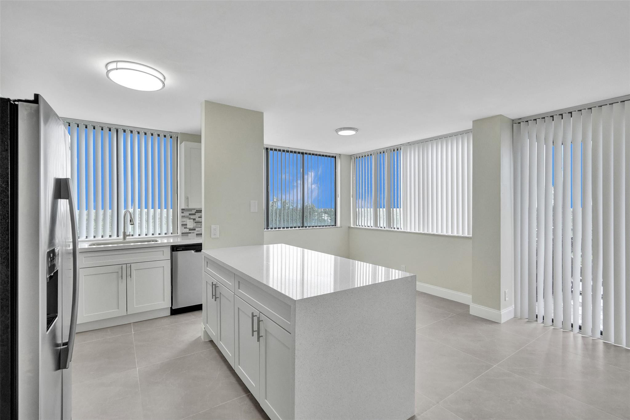 4222 Inverrary Boulevard, Unit 4810 Lauderhill, FL 33319 - Photo 5 of 63 a large kitchen with a sink and dishwasher a oven with white cabinets