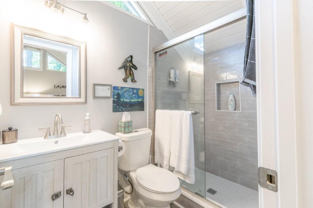 1944 Wilderness Parkway Jasper, GA 30143 - Photo 19 of 26 a bathroom with a toilet a sink and glass door