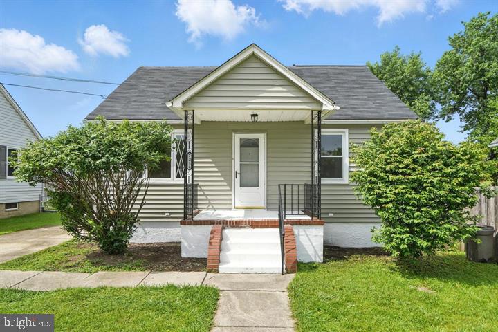 a front view of a house with a yard and trees