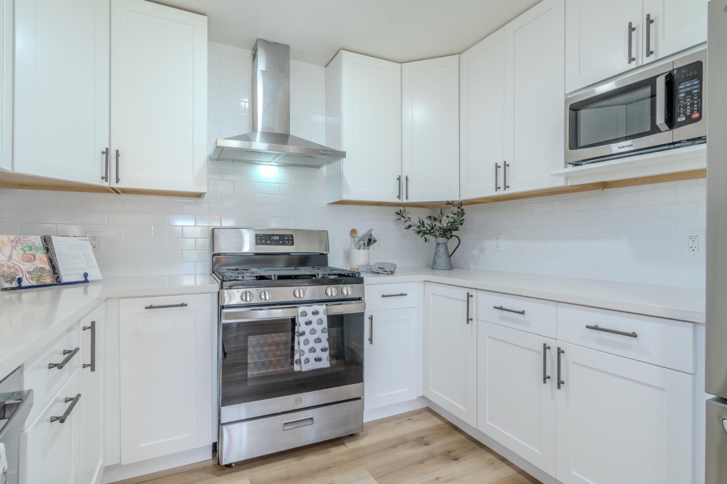 1324 Peralta Road Pacifica, CA 94044 - Photo 14 of 35 a kitchen with stainless steel appliances white cabinets and a stove a oven with white countertops