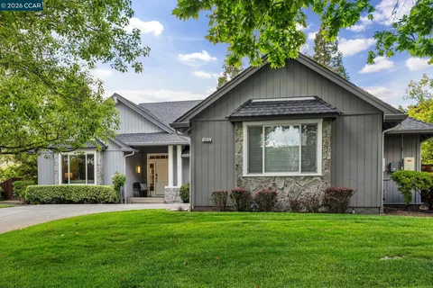 a front view of a house with a garden and yard