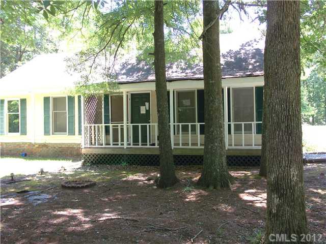 front view of a house with a large window and plants