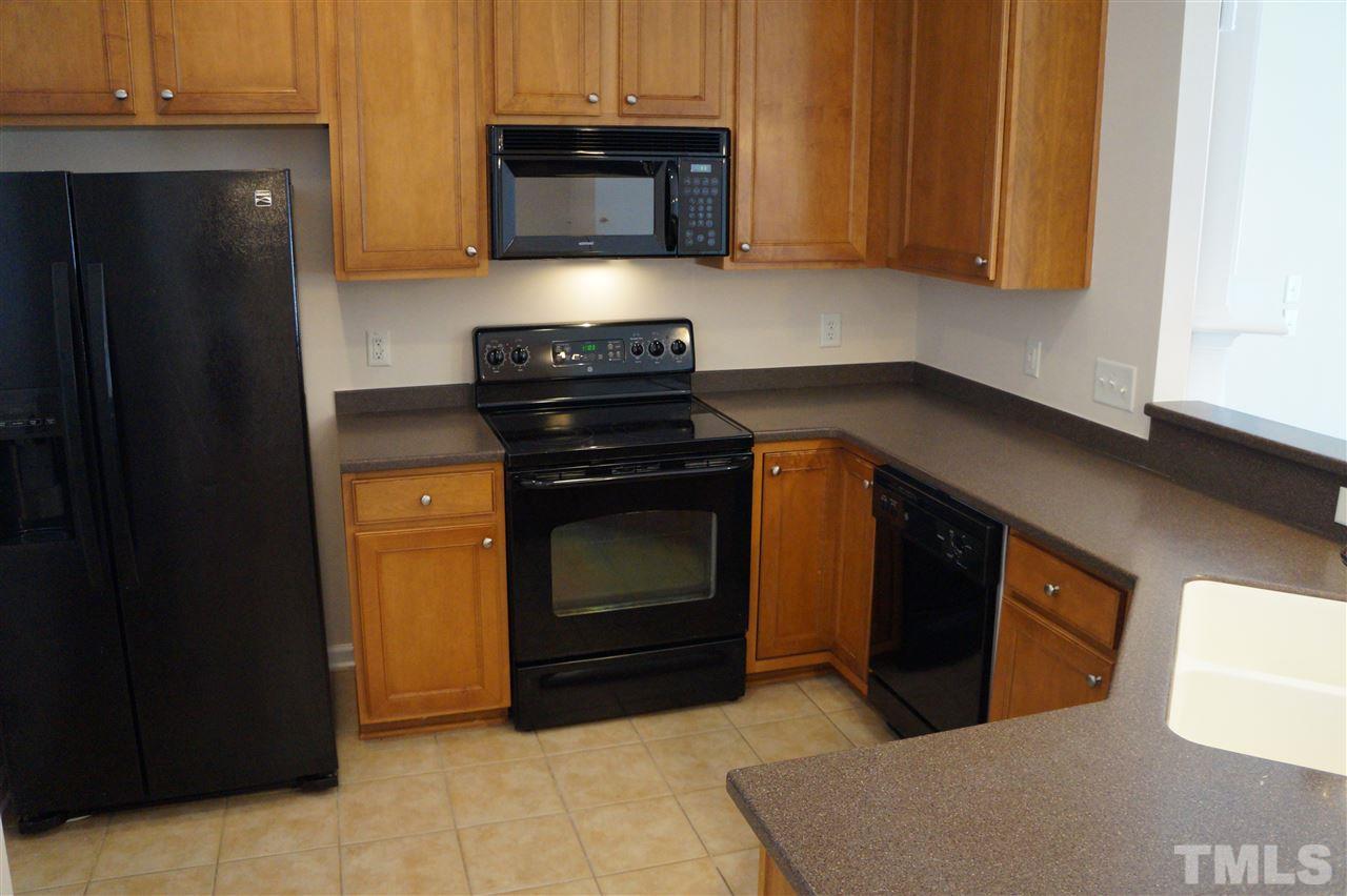 7036 Racine Way Raleigh, NC 27615 - Photo 5 of 22 a kitchen with stainless steel appliances granite countertop a stove and a microwave