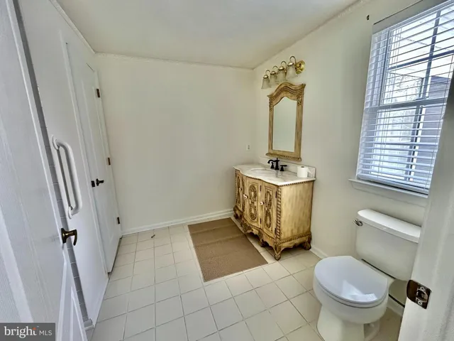 a bathroom with a granite countertop toilet sink and mirror