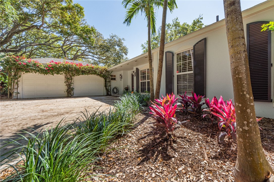 910 Seagrape Lane Vero Beach, FL 32963 - Photo 2 of 36 a front view of a house with a yard and a garden