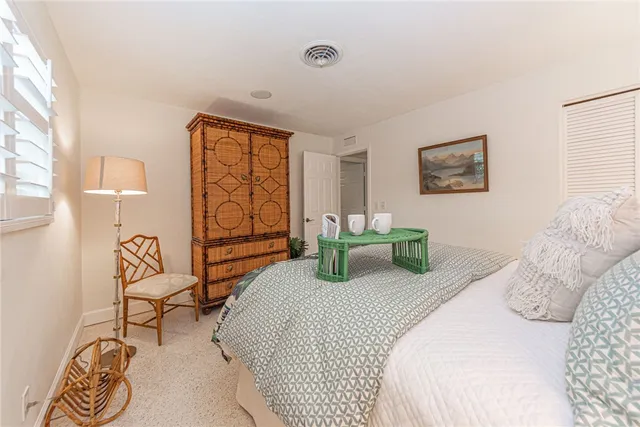 a bedroom with a bed a dresser and next to a window