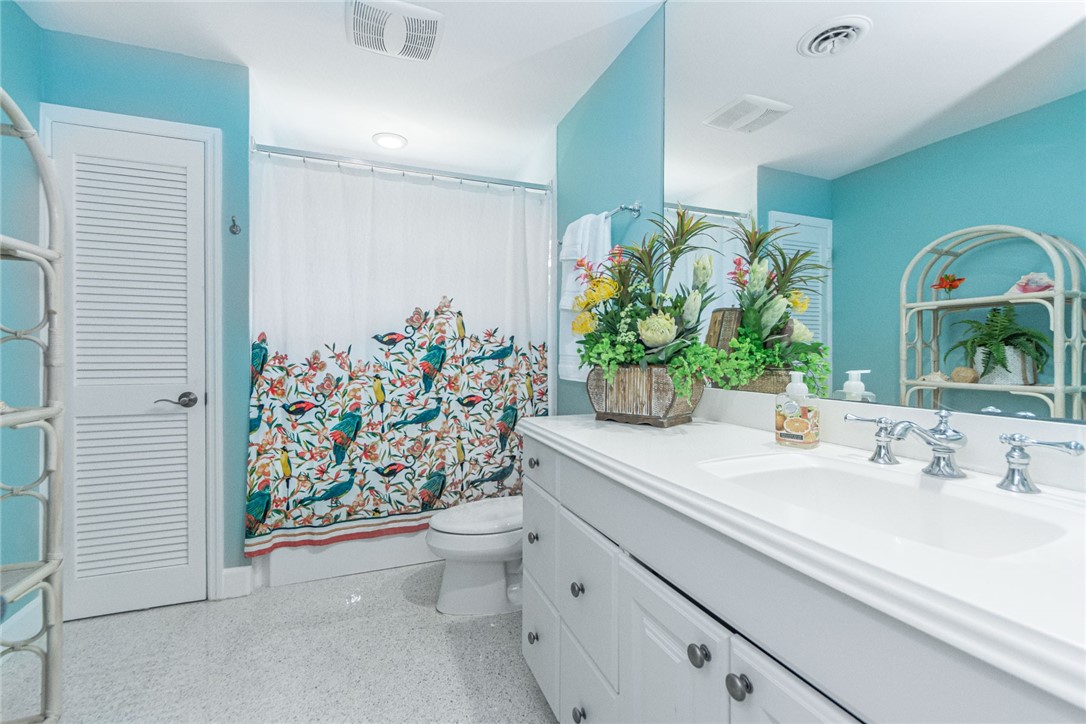 910 Seagrape Lane Vero Beach, FL 32963 - Photo 24 of 36 a bathroom with a sink a vanity and a shower curtain