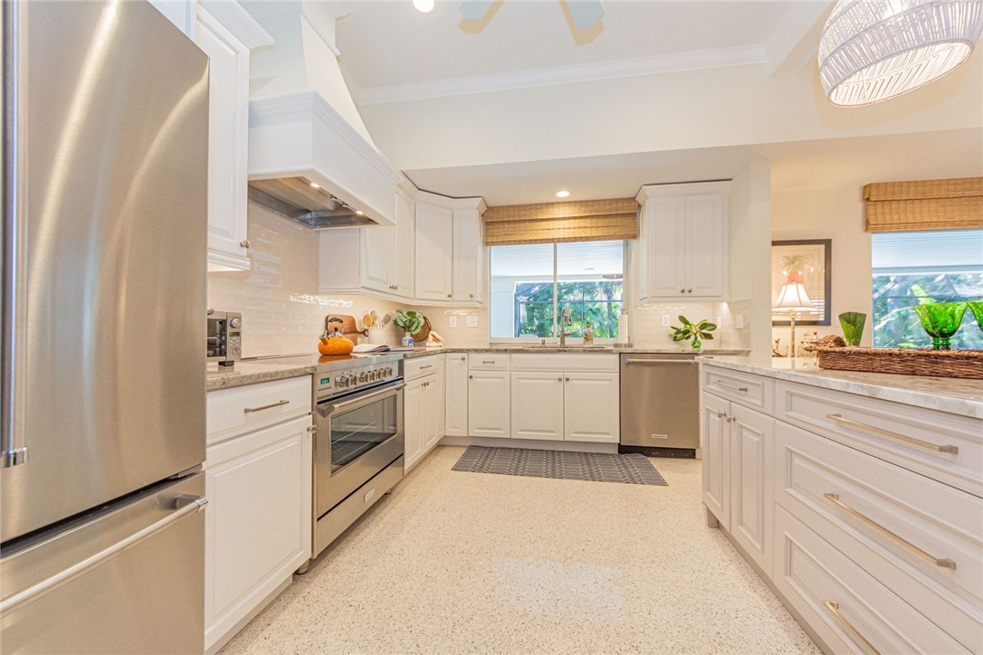 910 Seagrape Lane Vero Beach, FL 32963 - Photo 7 of 36 a kitchen with white cabinets and white appliances