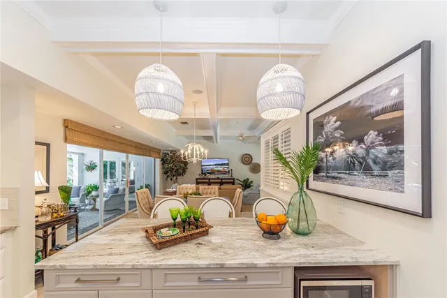 a view of a dining room with furniture a chandelier and large windows