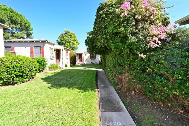 a view of house with backyard and a tree