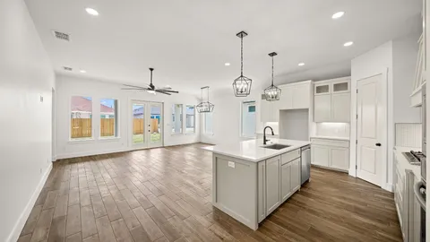 a kitchen with a stove and wooden floor
