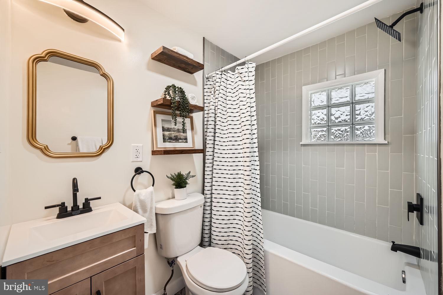 2415 Hammonds Ferry Road Halethorpe, MD 21227 - Photo 17 of 26 a bathroom with a sink a mirror a toilet and a bathtub