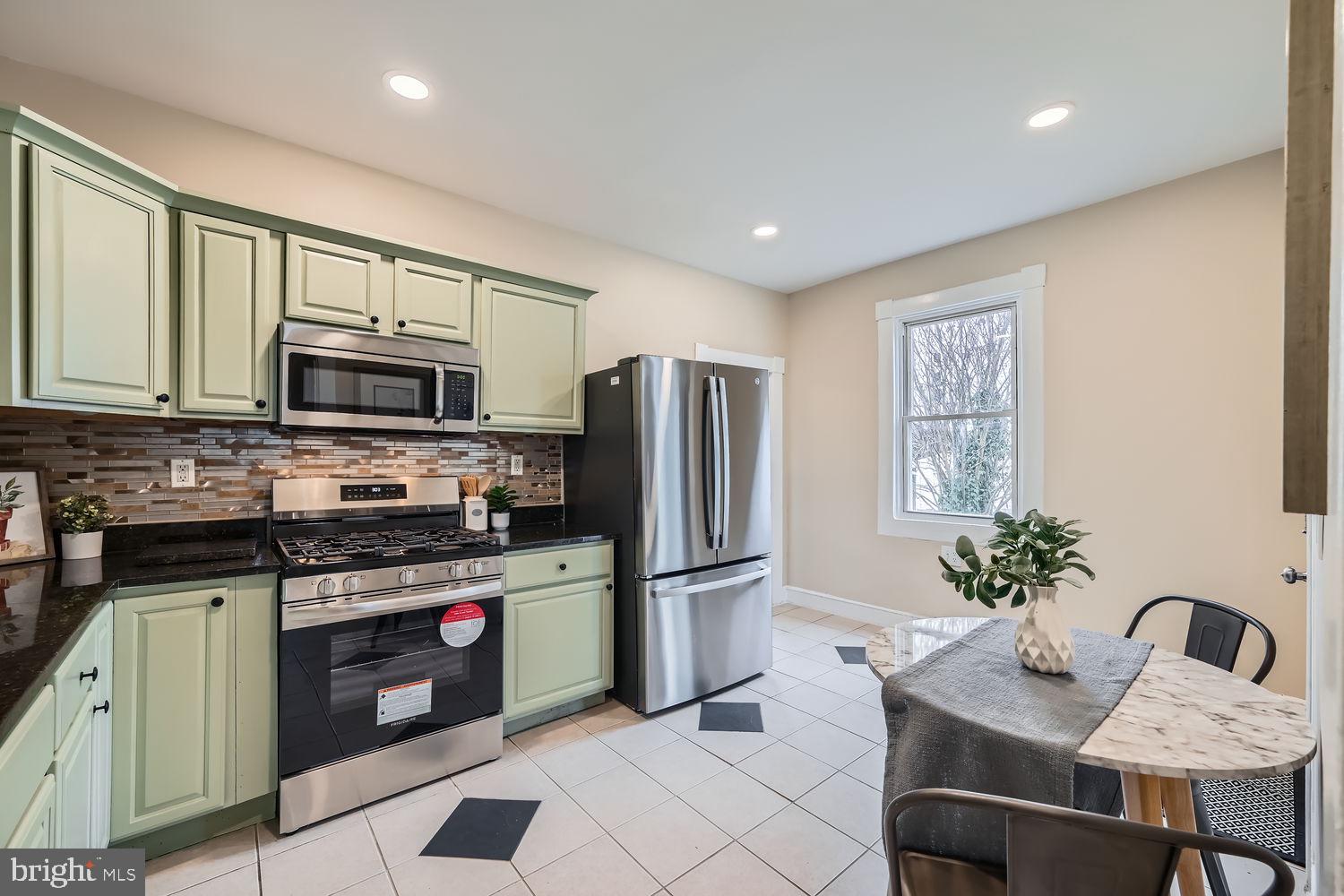 2415 Hammonds Ferry Road Halethorpe, MD 21227 - Photo 9 of 26 a kitchen with stainless steel appliances granite countertop a refrigerator a stove a sink a microwave and dining table