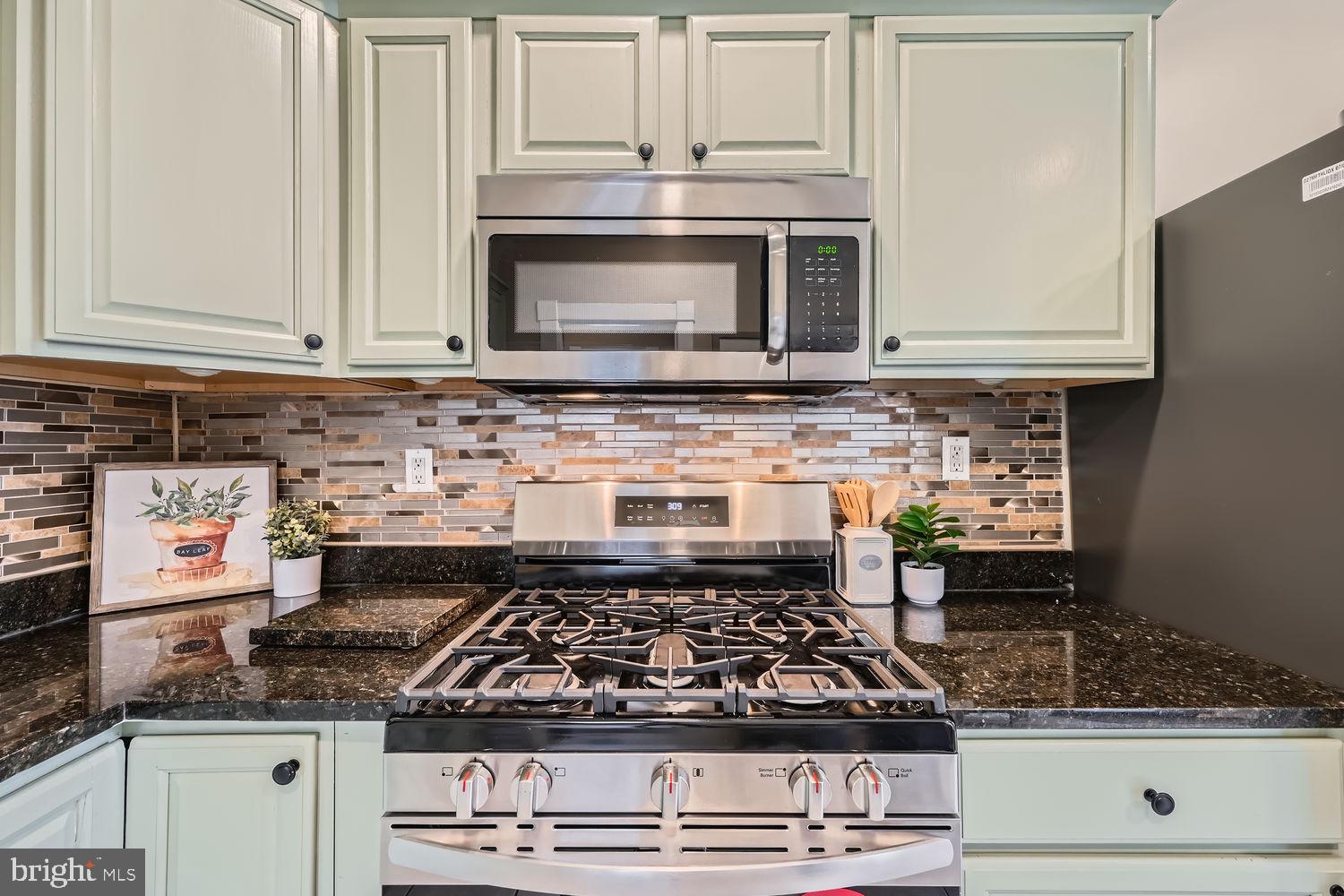 2415 Hammonds Ferry Road Halethorpe, MD 21227 - Photo 10 of 26 a kitchen with stainless steel appliances granite countertop a stove a microwave and cabinets