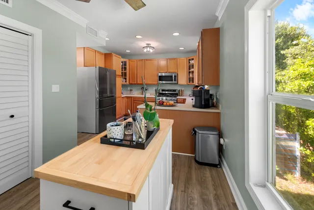 a kitchen with stainless steel appliances a refrigerator sink and wooden floor