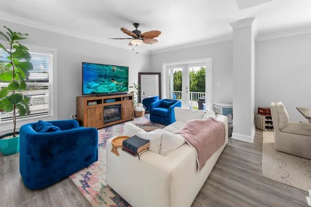 a living room with furniture a flat screen tv and a large window