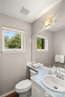 a bathroom with a toilet a sink and mirror