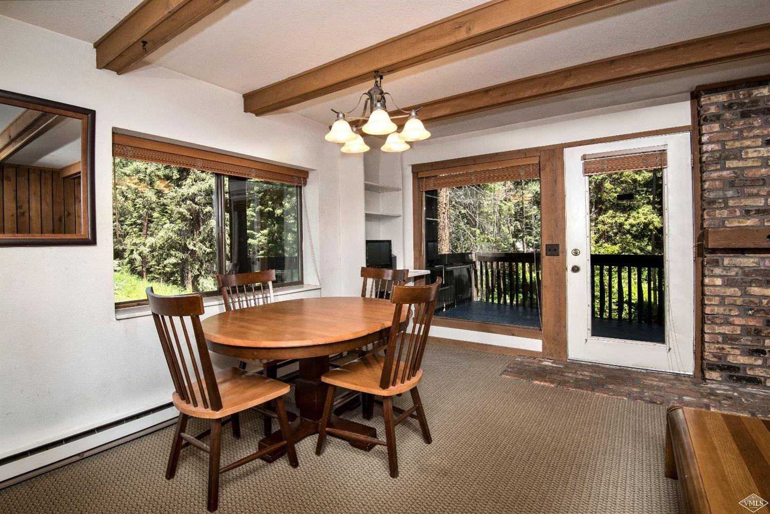 4570 Vail Racquet Club Drive, Unit 21 Vail, CO 81657 - Photo 3 of 16 a dining room with furniture a chandelier and window