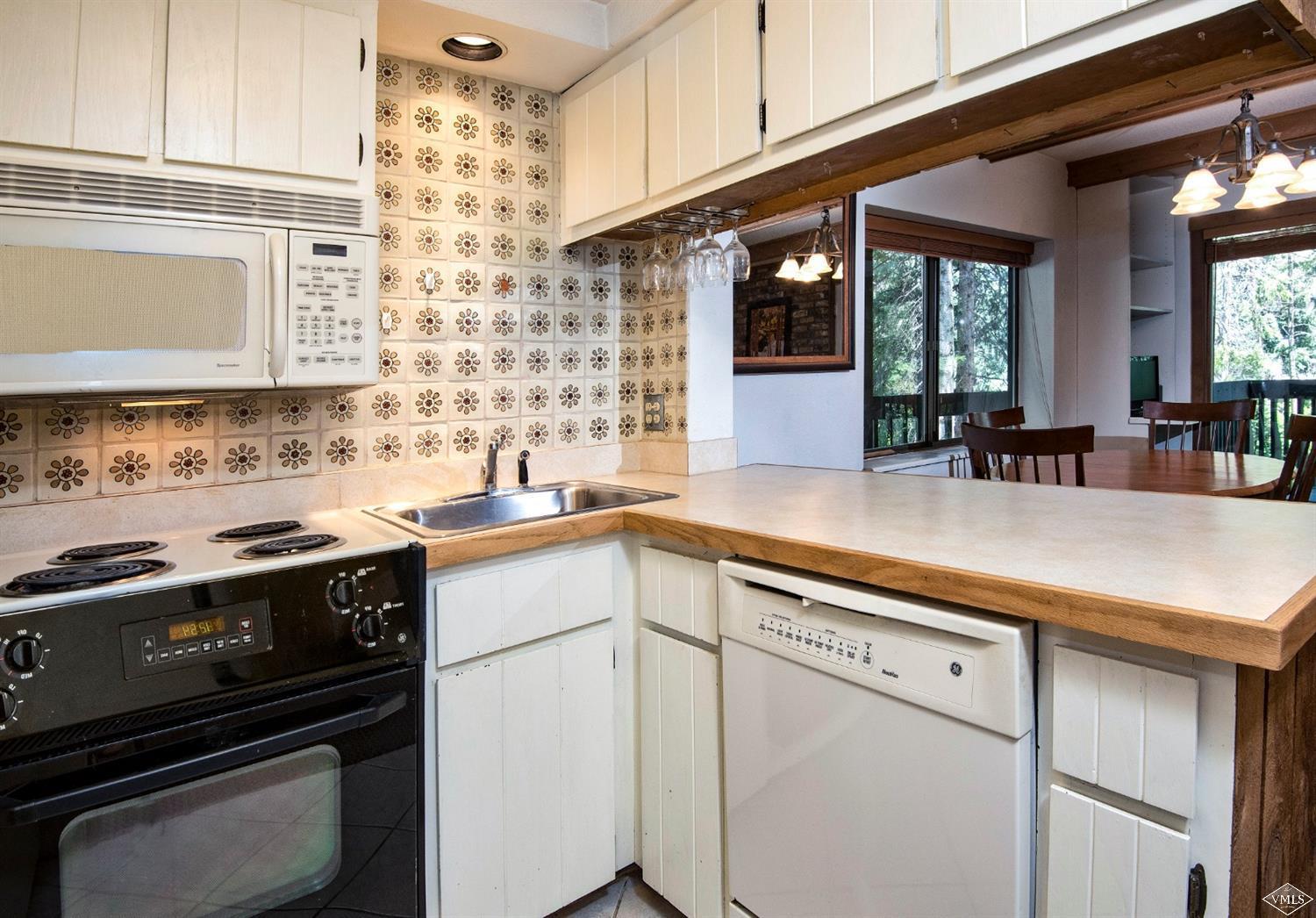 4570 Vail Racquet Club Drive, Unit 21 Vail, CO 81657 - Photo 8 of 16 a kitchen with a stove and white cabinets