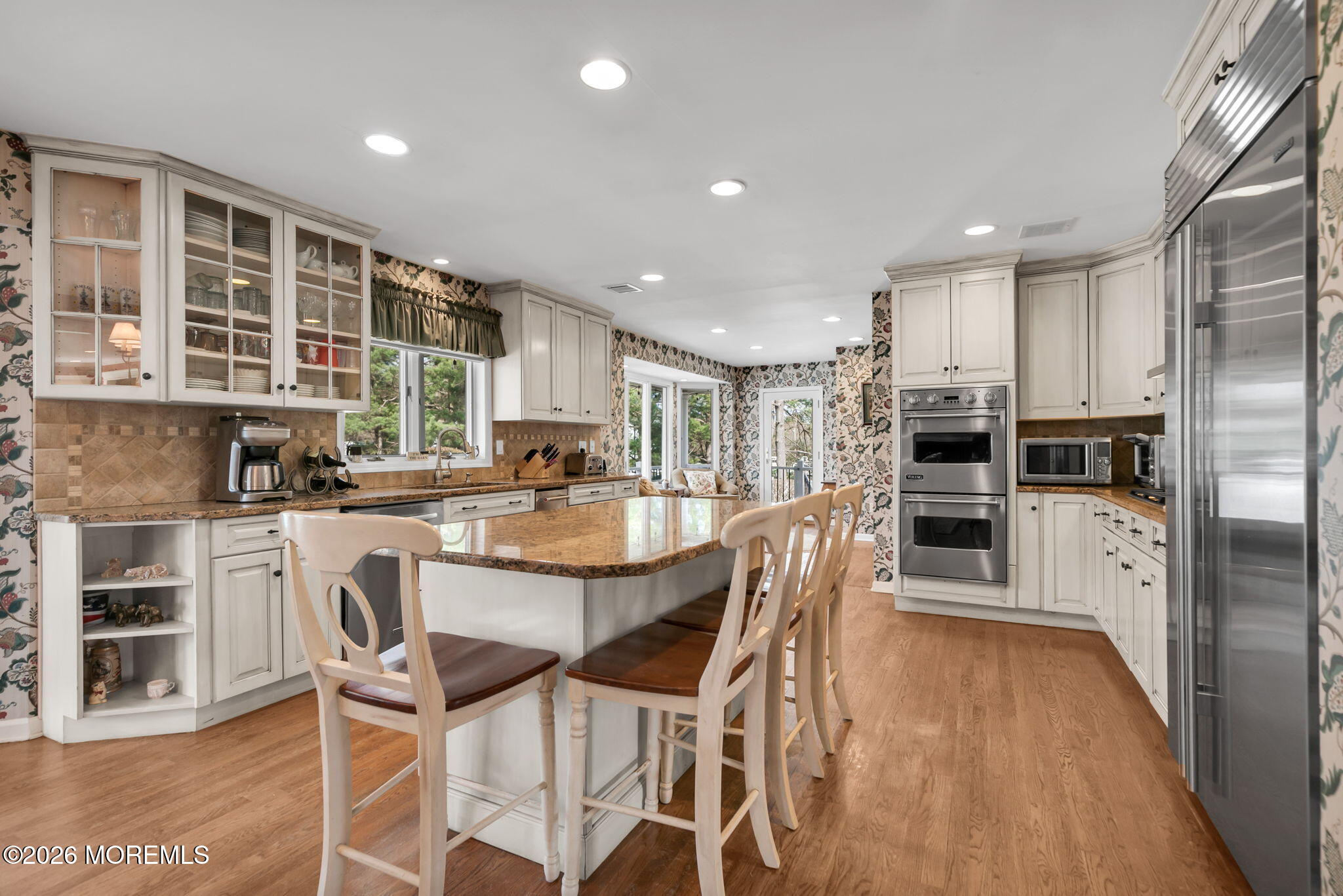 10 Paddock Lane Colts Neck, NJ 07722 - Photo 31 of 55 a kitchen with kitchen island granite countertop wooden floor and stainless steel appliances