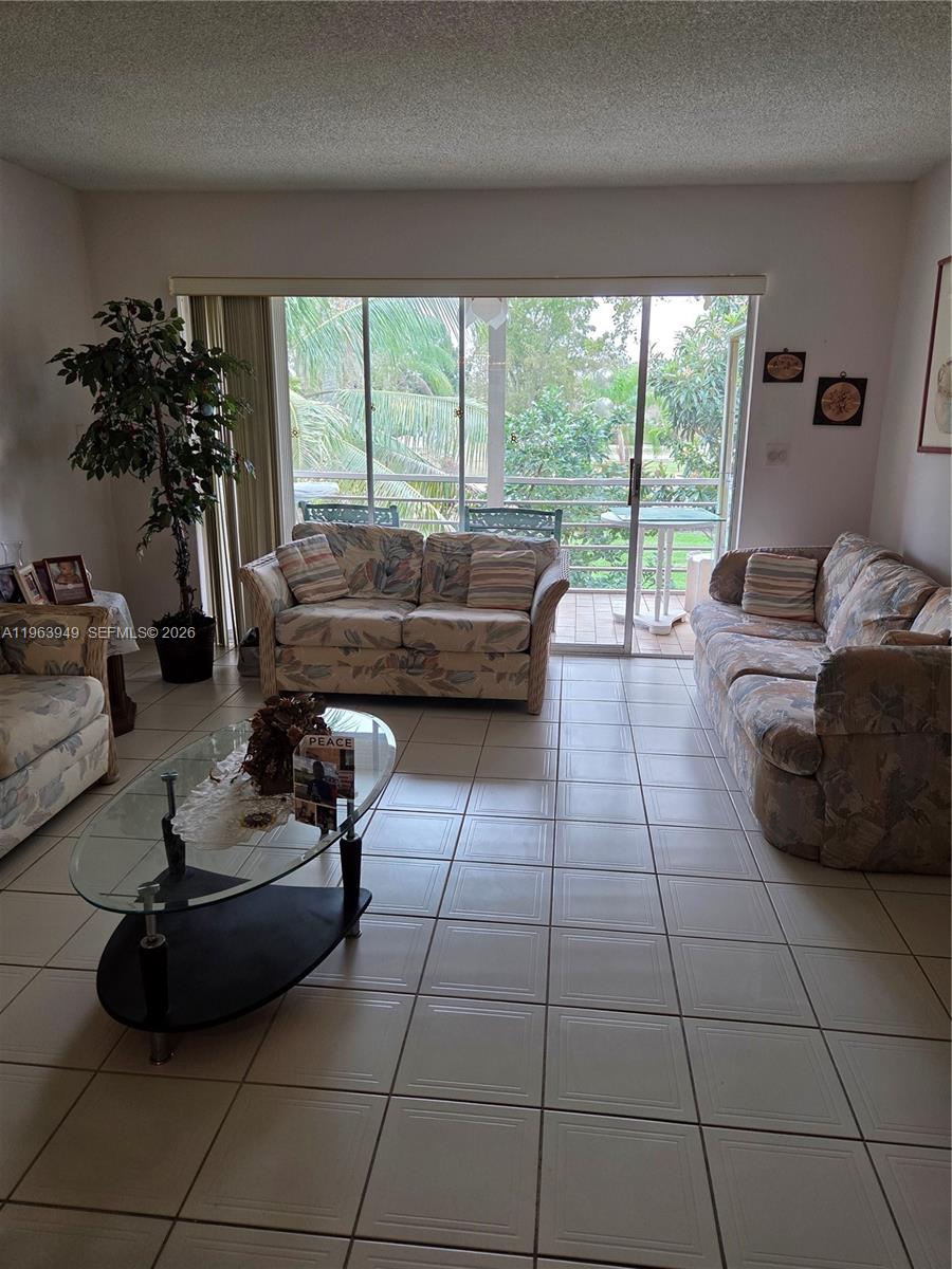 8834 West McNab Road, Unit 201 Tamarac, FL 33321 - Photo 11 of 27 a living room with furniture and a large window