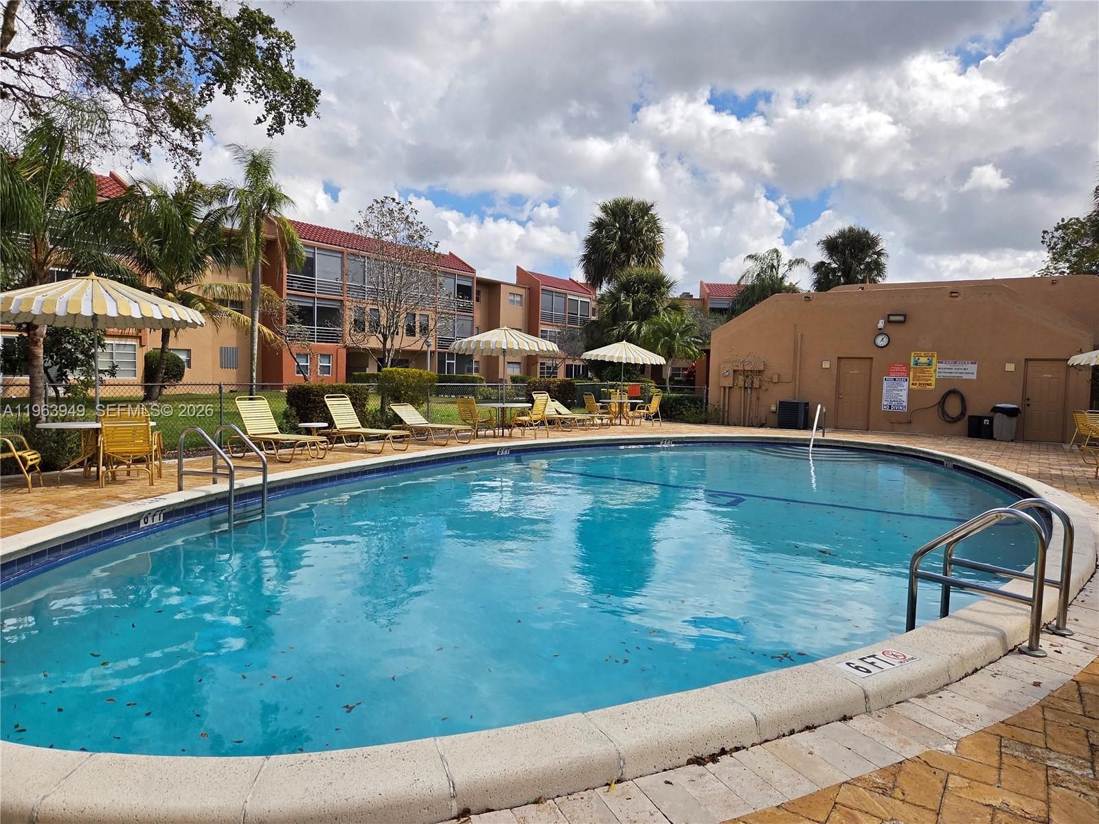 8834 West McNab Road, Unit 201 Tamarac, FL 33321 - Photo 19 of 27 a view of a swimming pool with an outdoor seating