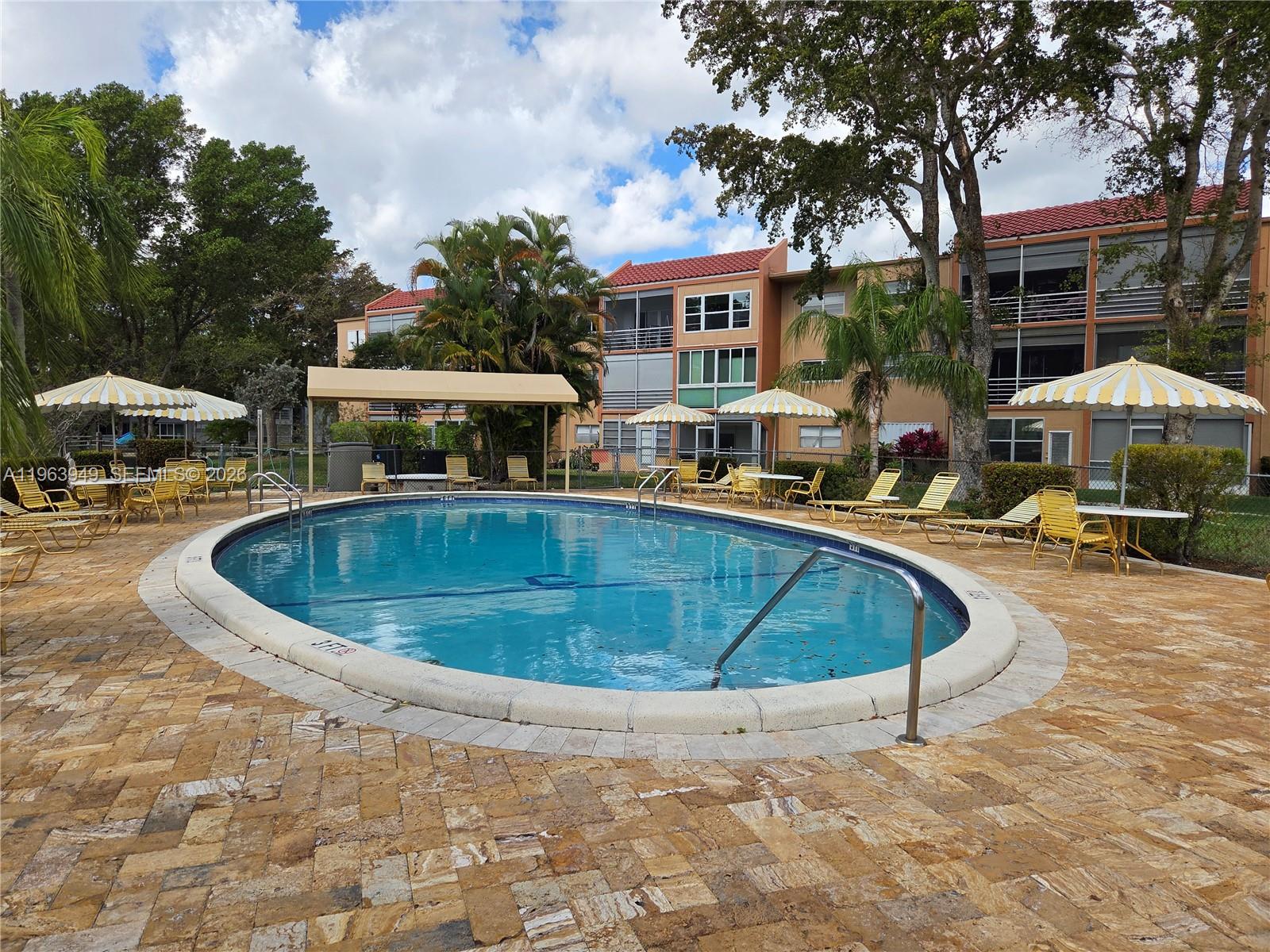 8834 West McNab Road, Unit 201 Tamarac, FL 33321 - Photo 20 of 27 a view of a swimming pool with outdoor seating
