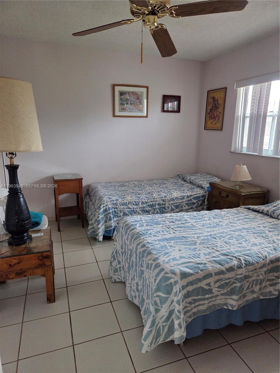 8834 West McNab Road, Unit 201 Tamarac, FL 33321 - Photo 7 of 27 a bedroom with a bed and a lamp on table