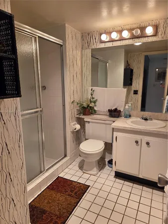 a bathroom with a toilet a sink and mirror