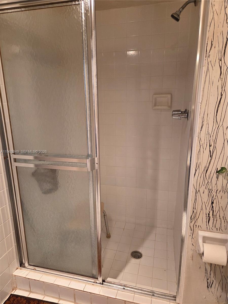 8834 West McNab Road, Unit 201 Tamarac, FL 33321 - Photo 9 of 27 a bathroom with a glass shower door