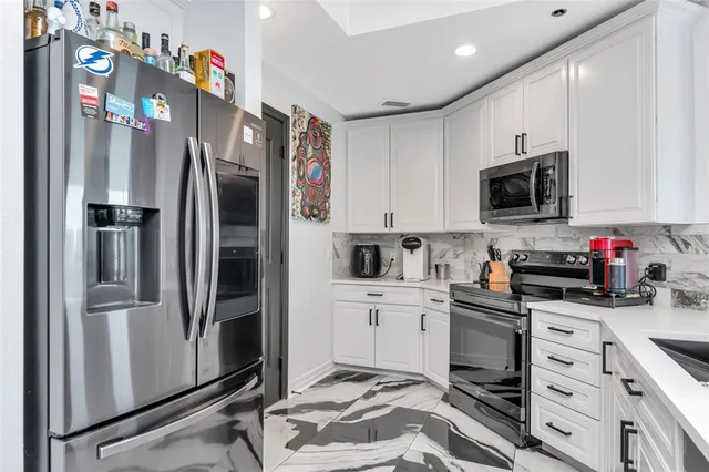 a kitchen with stainless steel appliances granite countertop a refrigerator and microwave