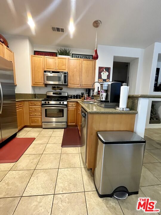 17983 Lost Canyon Road, Unit 116 Canyon Country, CA 91387 - Photo 8 of 11 a kitchen with stainless steel appliances kitchen island granite countertop a sink and cabinets