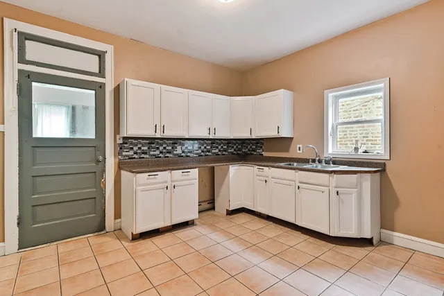 a kitchen with granite countertop white cabinets and white appliances