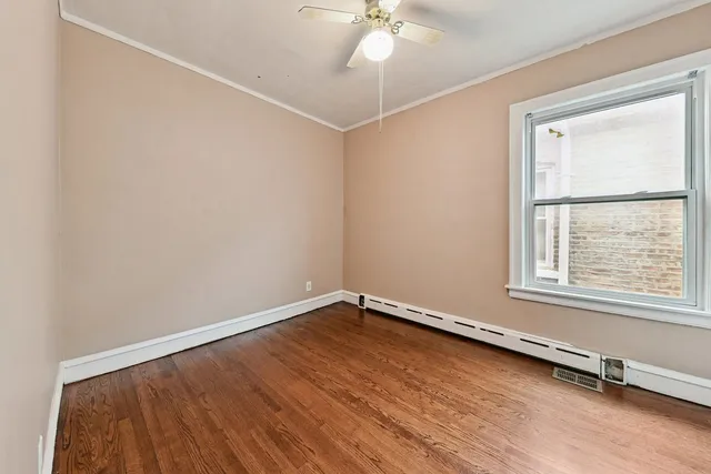 an empty room with a window and wooden floor