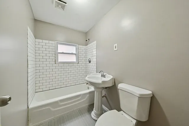 a white toilet sitting next to a bathroom sink