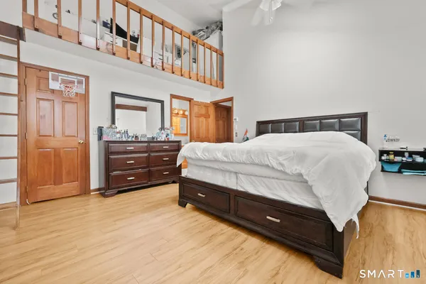 a spacious bedroom with a bed and wooden floor