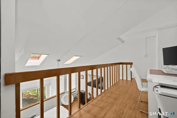 a view of a hallway with furniture and wooden floor