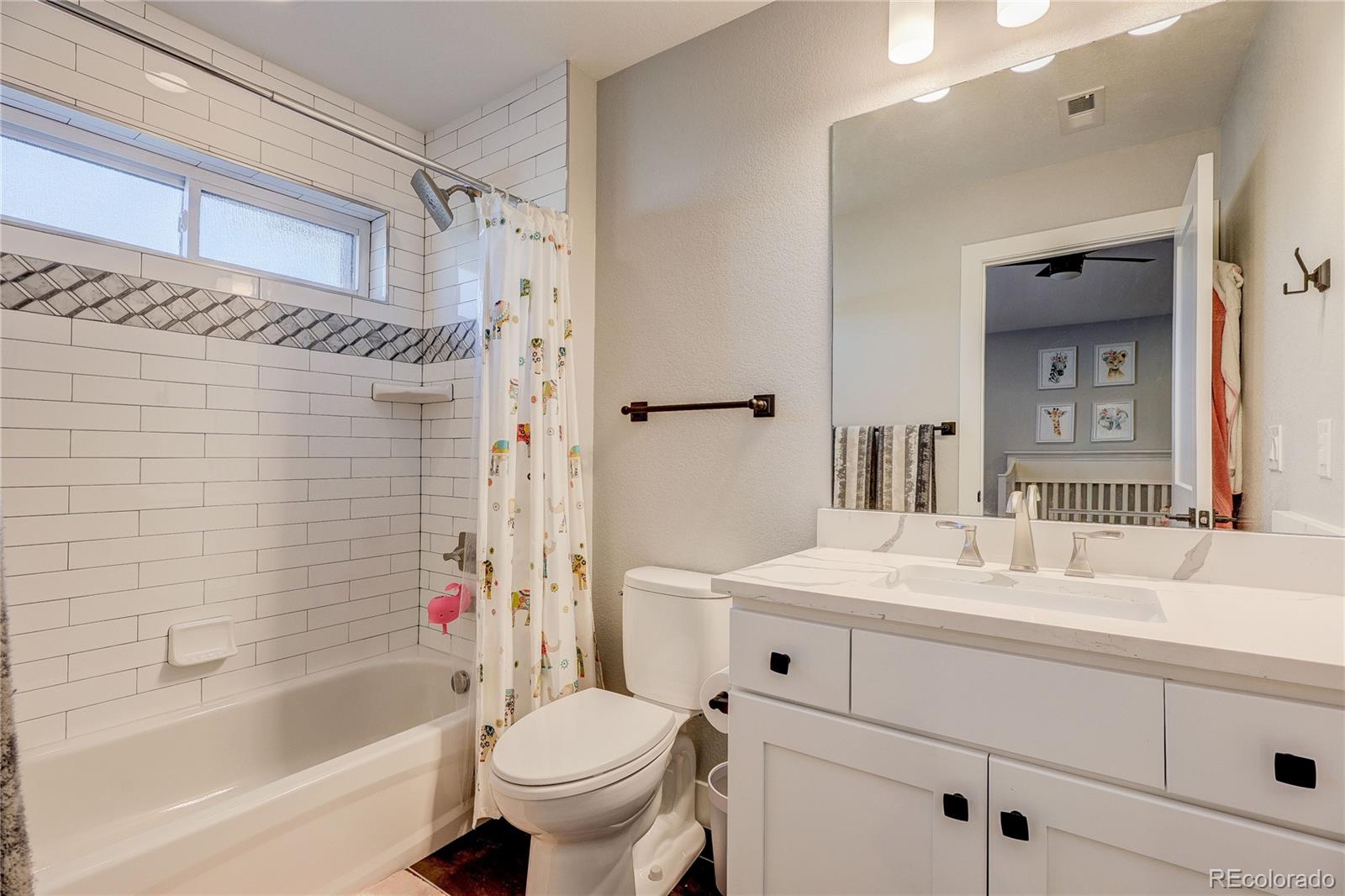 4792 South Acoma Street Englewood, CO 80110 - Photo 14 of 19 a bathroom with a sink toilet vanity and shower