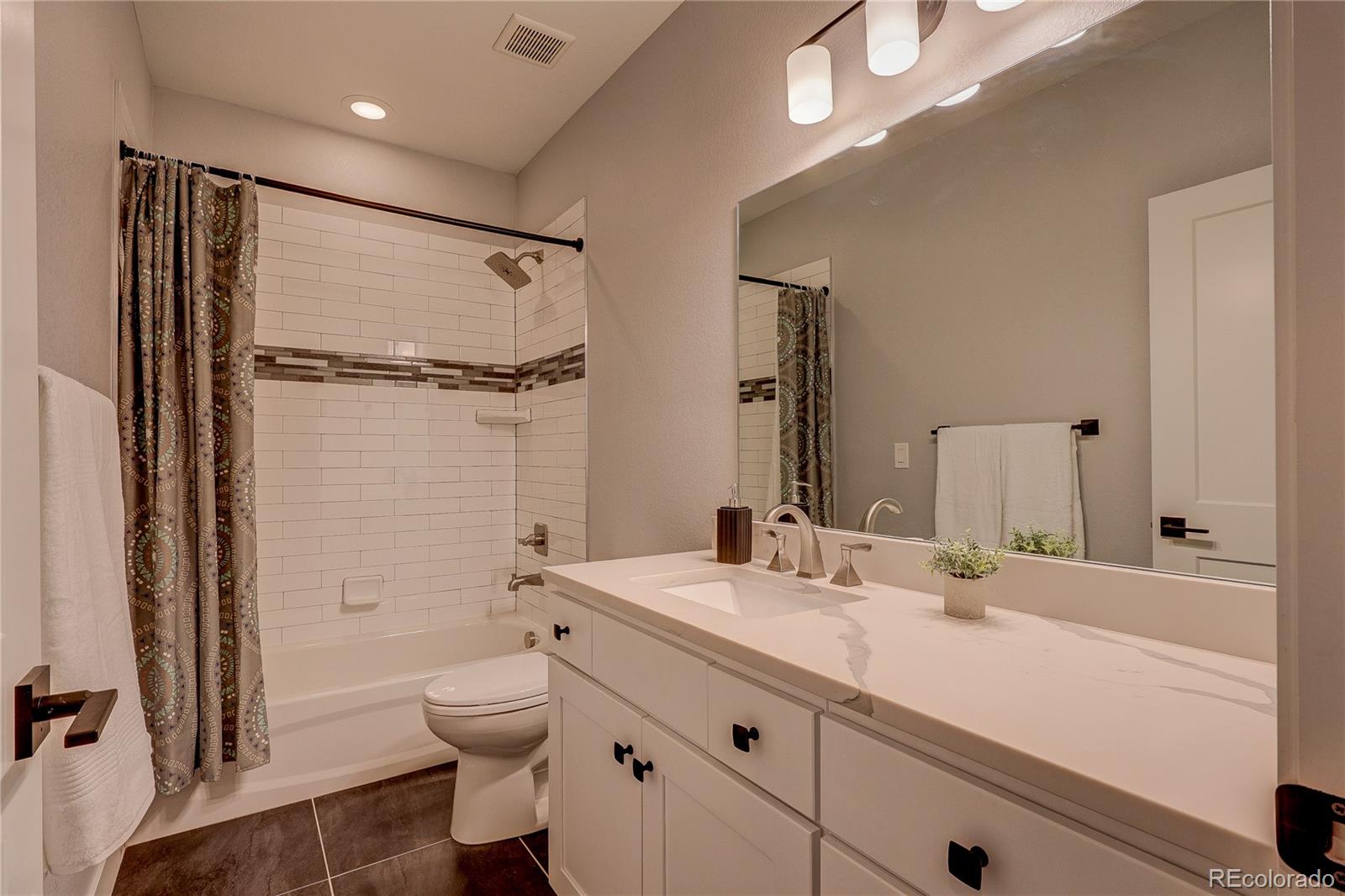 4792 South Acoma Street Englewood, CO 80110 - Photo 17 of 19 a bathroom with a granite countertop sink toilet and shower
