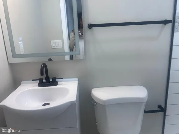 a bathroom with a sink a toilet and a mirror