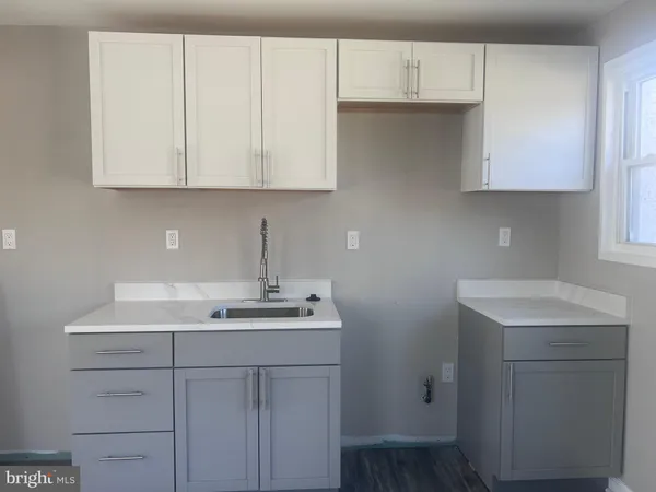 a kitchen with white cabinets sink and dishwasher